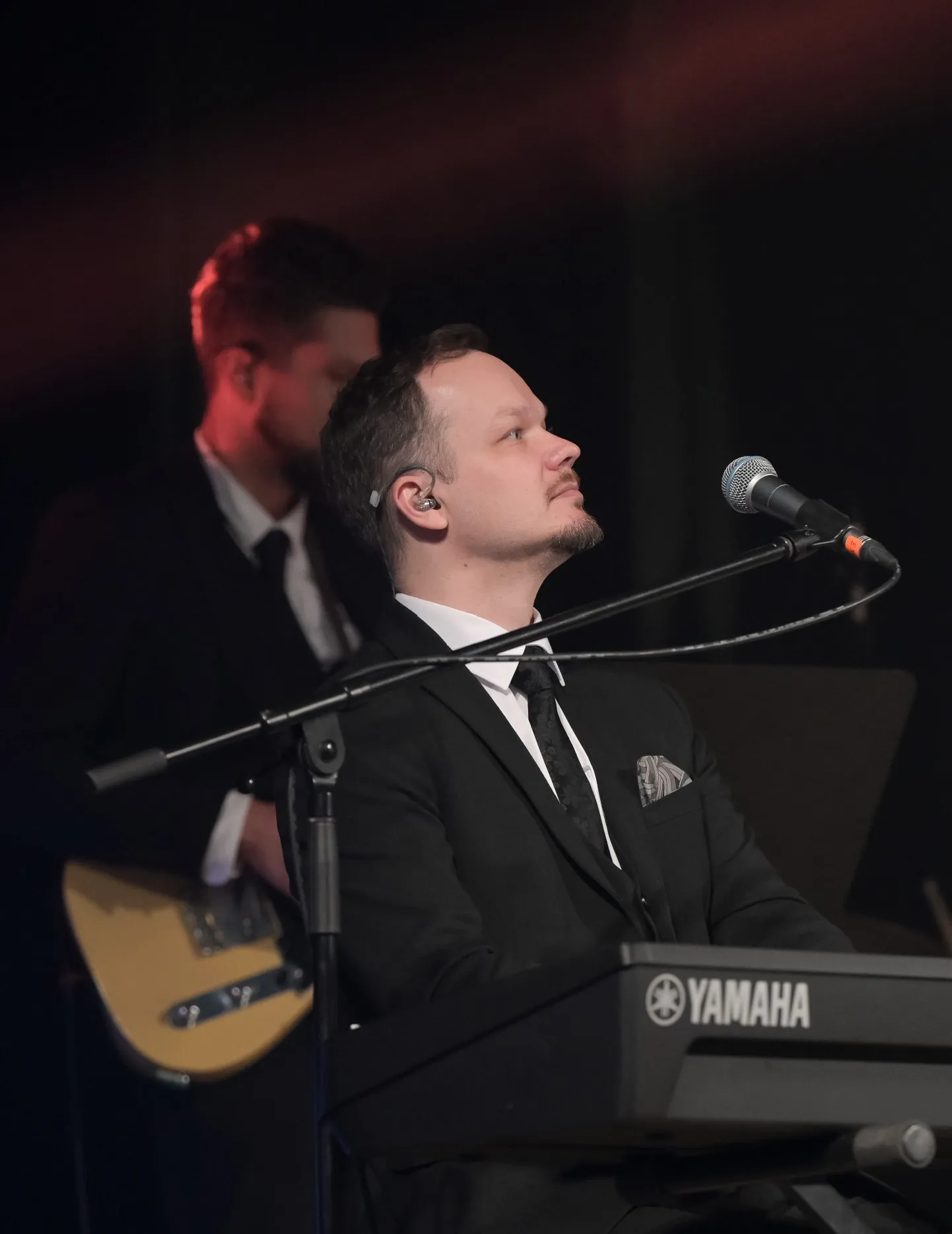 Dāvis Bindemanis pie taustiņinstrumentiem un mikrofona uz skatuves